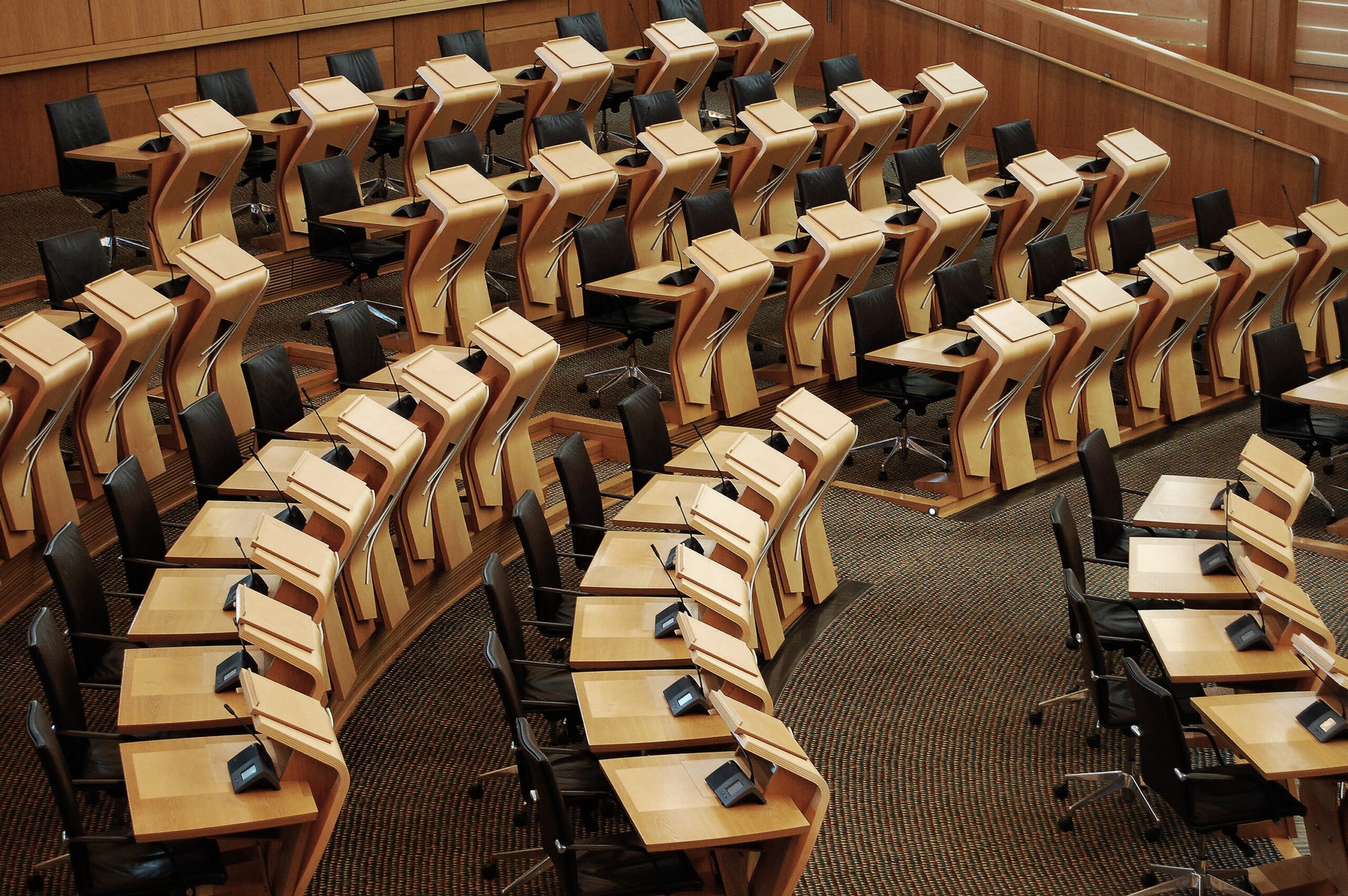 A horizontal shot of the desks inside of the Scottish parliament building